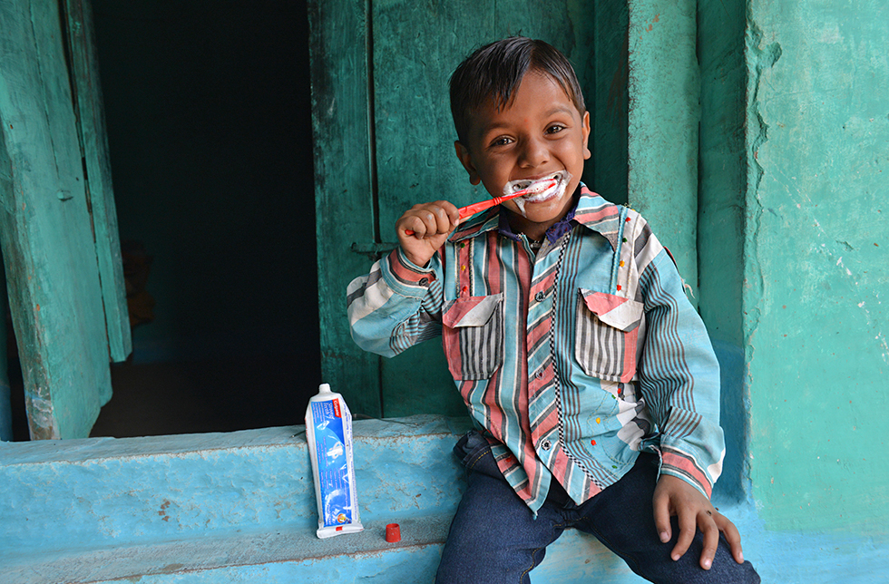 Ein Junge beim Zähneputzen in Aparajita, Indien